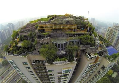 　　昨日，身穿橘黃色馬甲的工作人員在人濟(jì)山莊樓頂拆除違章建筑。新京報(bào)記者 吳江 攝