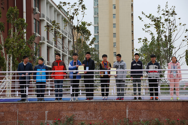 副校長賈軍杰（左一）為創(chuàng)新機器人社團的學生頒發(fā)證書