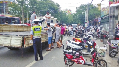 路旁的非機(jī)動車道已被多輛違法停放的電動車和自行車占滿