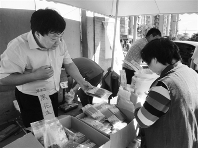 昨日，河南企業(yè)家劉春喜在京“練攤”，為顧客挑選綠豆。新京報(bào)記者 張玉學(xué) 攝