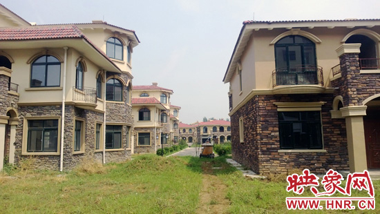 圖為別墅群內(nèi)正在進行最后的鋪路、綠化