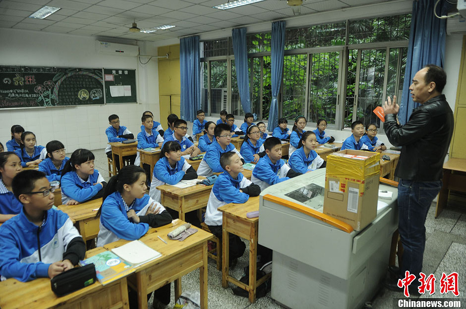 圖為老師正在向同學(xué)們講解用非智能手機對他們的好處。