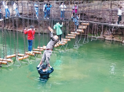 中年男游客正踩著景區(qū)安全員郭小明的肩膀過河。網(wǎng)友“@我的小名叫張孩”供圖