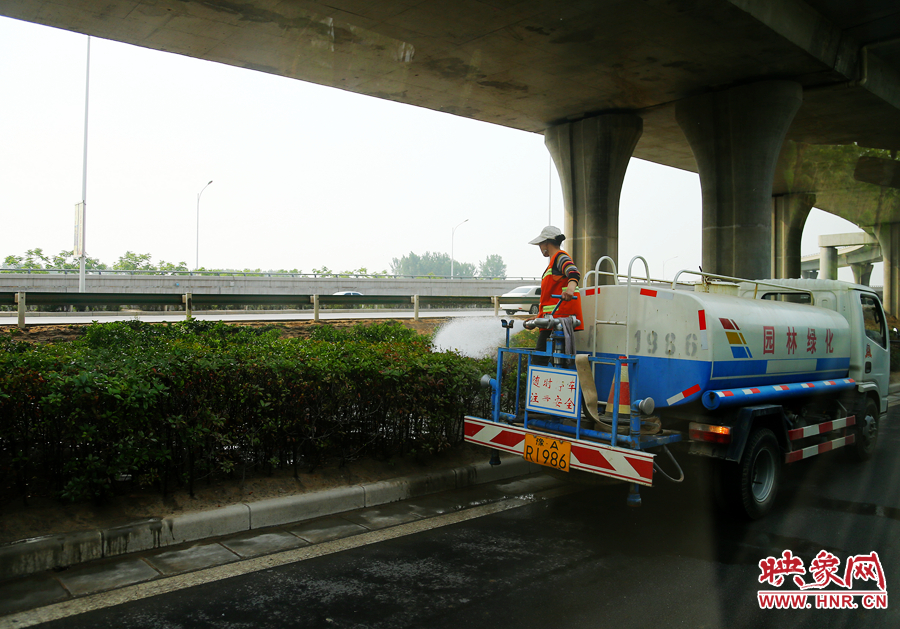 環(huán)衛(wèi)工人對(duì)綠化帶進(jìn)行養(yǎng)護(hù)