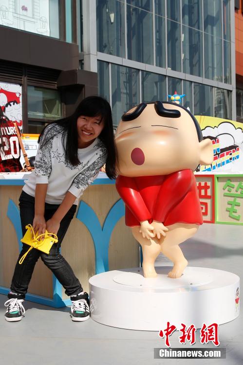 4月22日，游客與蠟筆小新合影。“蠟筆小新25周年紀(jì)念特展”日前在北京開(kāi)展，吸引了不少市民游客。