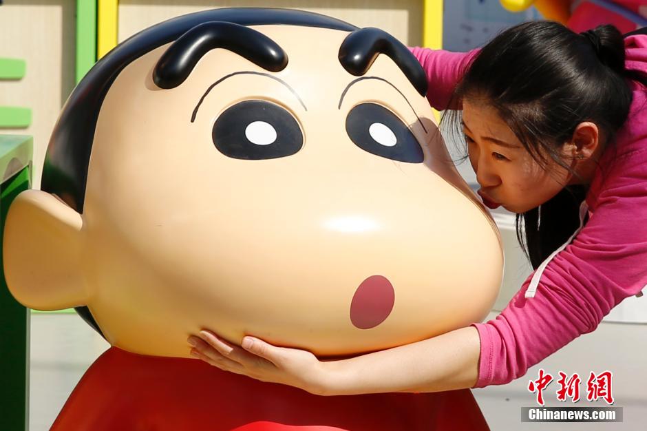 4月22日，游客與蠟筆小新合影?！跋灩P小新25周年紀(jì)念特展”日前在北京開(kāi)展，吸引了不少市民游客。