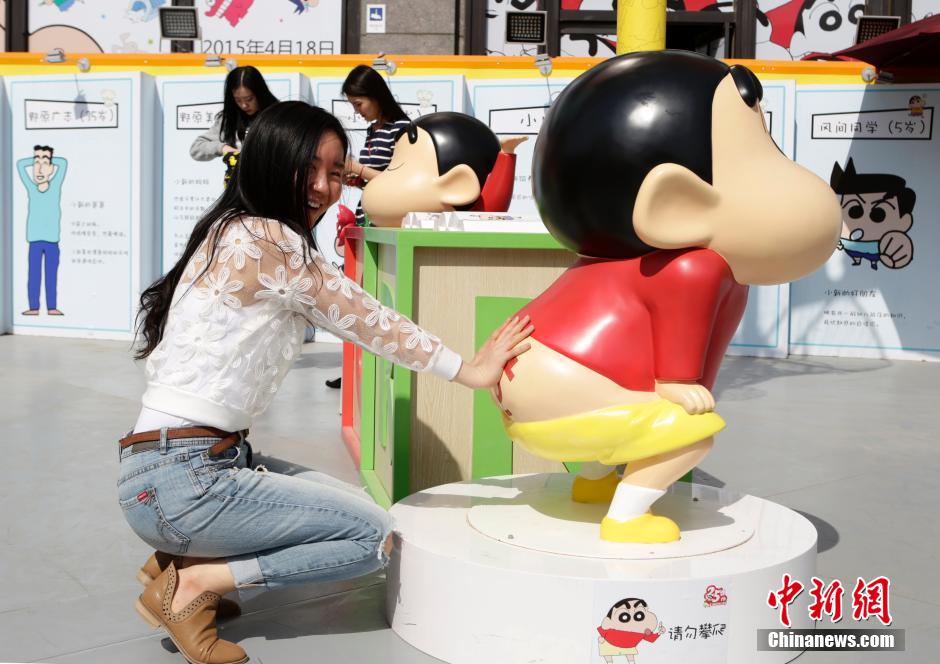 4月22日，游客與蠟筆小新合影?！跋灩P小新25周年紀(jì)念特展”日前在北京開(kāi)展，吸引了不少市民游客。