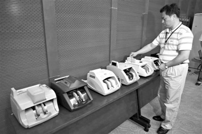 昨日，央行工作人員用各種驗鈔機對C1F9假幣進行測試，機器均能及時作出異常報警反應(yīng)。新京報記者 浦