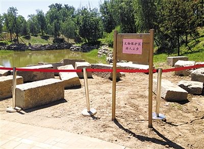 圓明園規(guī)月橋橋體構(gòu)件區(qū)域的警戒線和提示牌。 新京報(bào)記者 鄧琦 攝