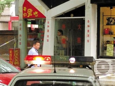 闖入面館的持刀男子與趕來的民警隔著玻璃門對峙，后店內(nèi)一名女童被其劫持。網(wǎng)友供圖