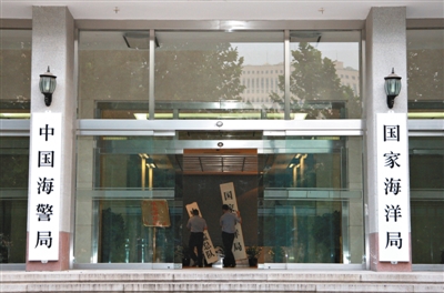 昨日，中國海警局掛牌成立。原國家海洋局和中國海監(jiān)總隊的牌匾被摘下，國家海洋局和中國海警局的新牌匾換上。黃冉 攝