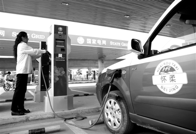 9月11日，懷柔區(qū)，電動(dòng)出租車司機(jī)正在為車輛充電。