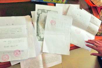 60歲的市民仇先生為了辦理公證所需的這些證明材料,半個月時間里跑了30多趟腿。記者　李萌博　攝