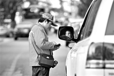 10月15日，朝陽區(qū)東大橋路，停車管理員從腰間掏出一個專用POS機，正在錄入停車信息。新京報記者 周崗峰 攝
