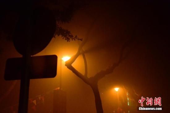 1月31日凌晨，市民行走在煙霧繚繞的南京街頭。當(dāng)天是農(nóng)歷馬年正月初一，南京有限開(kāi)禁燃放煙花爆竹正逢下霧天，空氣的不流通致使煙花爆竹燃燒后產(chǎn)生的顆粒物不能及時(shí)散開(kāi)，造成整座城市煙霧繚繞。據(jù)當(dāng)?shù)丨h(huán)保部門(mén)發(fā)布的信息顯示，空氣質(zhì)量屬重度污染。中新社發(fā) 泱波 攝