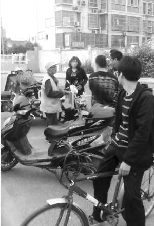 穿環(huán)衛(wèi)工作服的是顧大爺,旁邊的女子是車(chē)主