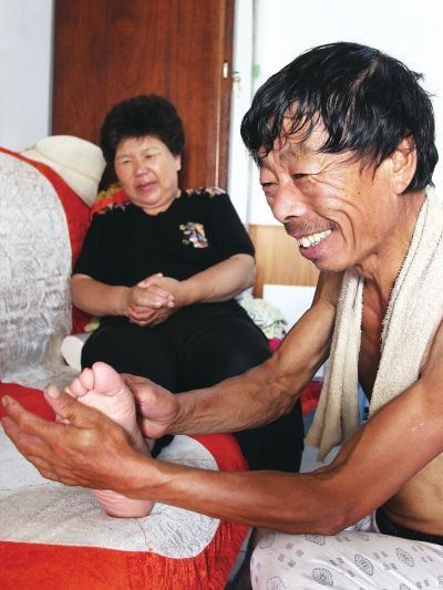 慈成富為老伴按摩。