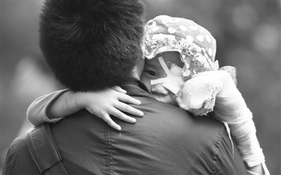 昨日，北京同仁醫(yī)院，被砍傷的彤彤趴在舅舅的肩上。他們剛剛掛完號，正準(zhǔn)備回旅館。新京報記者 尹亞飛 攝