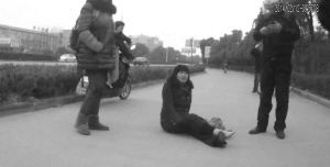 鄭大姐坐在地上，警方趕到進行施救。（視頻截圖由警方提供）