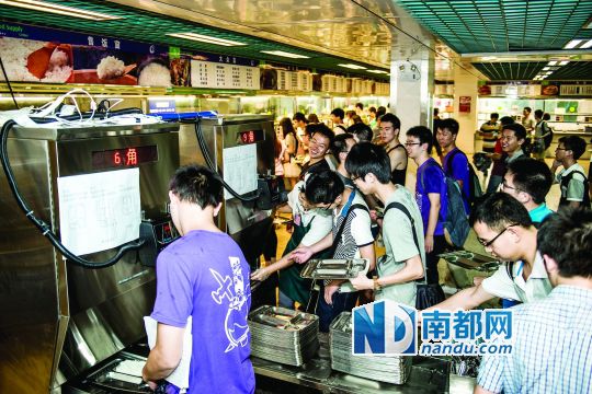 昨日，華南理工大學一食堂內，學生們正在使用新安裝的自動打飯機打飯。中新社發(fā)