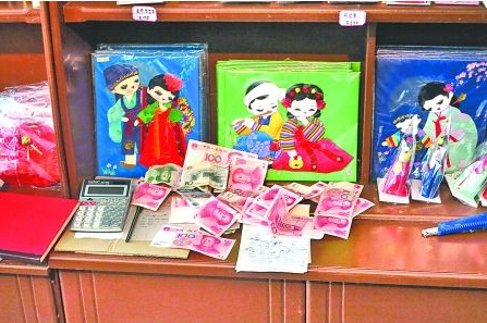 　　2012年6月21日，在朝鮮羅先特別市的一家商店里，柜臺上散落著一些人民幣。在朝鮮，人民幣比本國