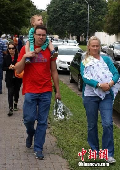 圖為一個(gè)白人家庭，由父母帶著孩子到曼德拉家門外悼念。中新社發(fā) 宋方燦 攝