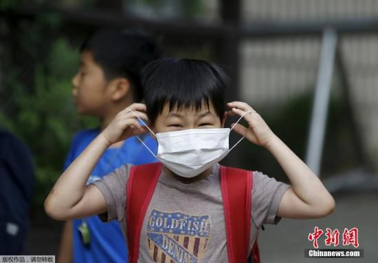圖為當(dāng)?shù)貢r(shí)間2015年6月8日，韓國(guó)未停課的學(xué)校，學(xué)生課前戴口罩測(cè)體溫。