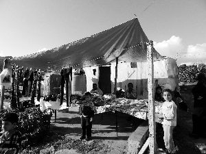 黎巴嫩一敘利亞難民營(yíng)，難民支起攤鋪賣衣服掙錢。