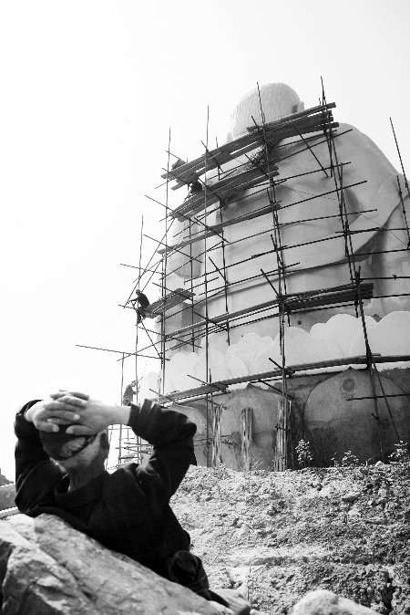 今年4月26日，工作人員將帆布蓋在“佛像”頭像上