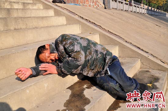 這名男子的衣服以及褲子全濕透了，水從衣褲里流出來，嘴里散發(fā)著濃烈的酒氣。