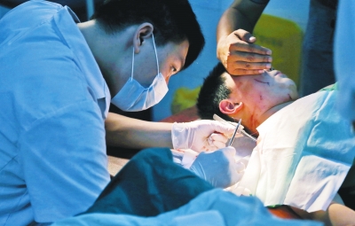 孩子身上有7道傷痕，其中兩道需要縫合，其他的均為擦傷，醫(yī)生正對他施治。