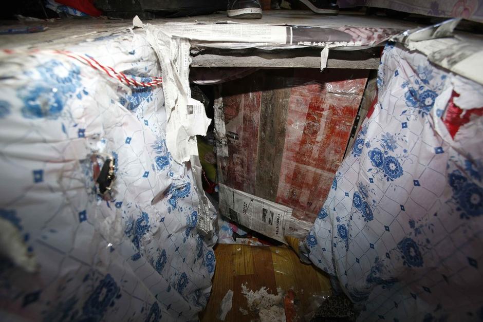 陳小龍?jiān)诔鲎馕萃?，自行又圍起一堵圍墻，安裝了一個(gè)門。圍墻上都是豎起的鐵釘，外面堆著土，鄰居猜是從地底挖出來的。洞口就在床邊，0.5米見方，深約1.5米。洞口表面一塊紙板掩蓋，打開紙板跳入洞底，是一扇小木門，木門外有插銷，可以從外面鎖上。