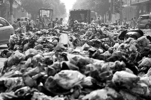 垃圾堆滿整個路口，環(huán)衛(wèi)工人們正在清理