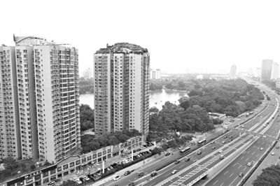 昨日，人濟山莊小區(qū)，與其他樓相比，B棟樓頂層天臺上違規(guī)建造了一棟兩層小樓，假山大樹俱全。新京報記者