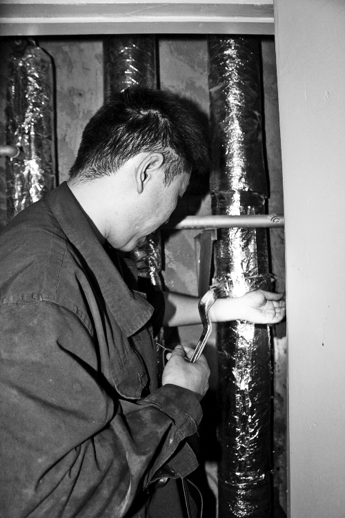 苗師傅一邊進(jìn)行維修，一邊用耳機(jī)接聽市民的電話。