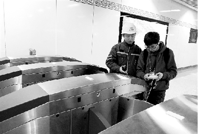 昨天上午，體育中心站，工作人員正在對進出站閘機進行調試。