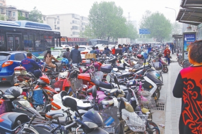 省人民醫(yī)院北門，路邊的公交站牌處停滿非機(jī)動(dòng)車，上、下客只能在快車道上。