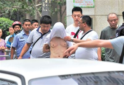 昨日，成都警方抓捕時與毒犯發(fā)生槍戰(zhàn)。一名男犯罪嫌疑人被警方押出。