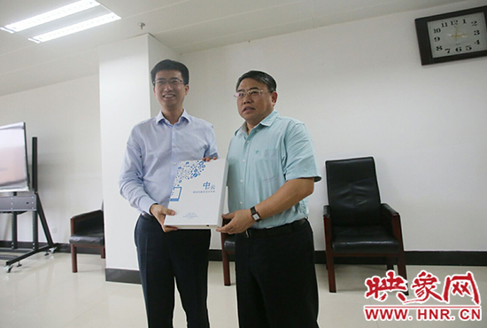 阿里云計(jì)算總裁胡曉明向河南省新聞出版廣電局局長(zhǎng)朱夏炎遞交《中原云平臺(tái)交付手冊(cè)》。