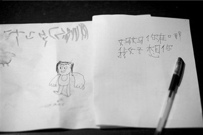 名叫袁明燕的小姑娘用筆在紙上不斷寫“媽媽”二字。