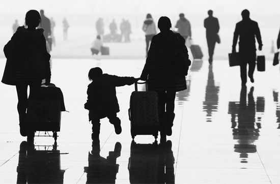 昨日，鄭州東站，一名孩子拉著媽媽和包裹快樂(lè)地奔走在春運(yùn)的途中