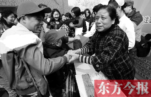 昨日，鄭大四附院的大樓前，“面人鄭”鄭玉芬（右）向前來(lái)捐款的殘疾人表示感謝