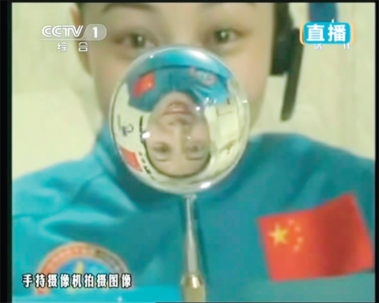 王亞平的倒影出現(xiàn)在水球中。新華社發(fā)（視頻截圖）