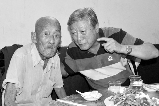 昨日，來自北京的英雄后代胡冠軍（右）專門趕到西平縣看望抗戰(zhàn)老兵孫殿修老人