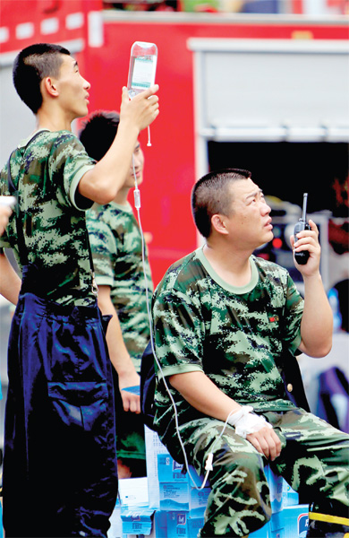 火場外，被消防戰(zhàn)士稱為“李大隊”的救援人員掛著吊瓶現(xiàn)場指揮