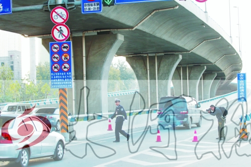 交警在東風(fēng)路從北向南上橋口處擺上反光錐，間歇放行