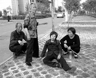 2013年4月28日，平頂山市市政府附近，受害者郭小蕊（化名）的家屬鳴冤，郭小蕊的母親杜玉花癱坐在地上。