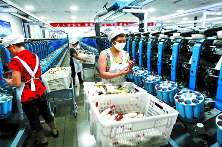 6月6日，舞鋼市鑫海紡織有限公司員工正在新建成的紡紗車間生產(chǎn)。