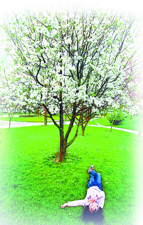 　孩子愜意地躺在社區(qū)內(nèi)的草坪上。