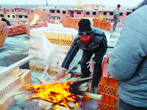 在俄羅斯工地打工時，因?yàn)樘焯?，工人不得不在工地生火取暖。（圖由方先生提供）